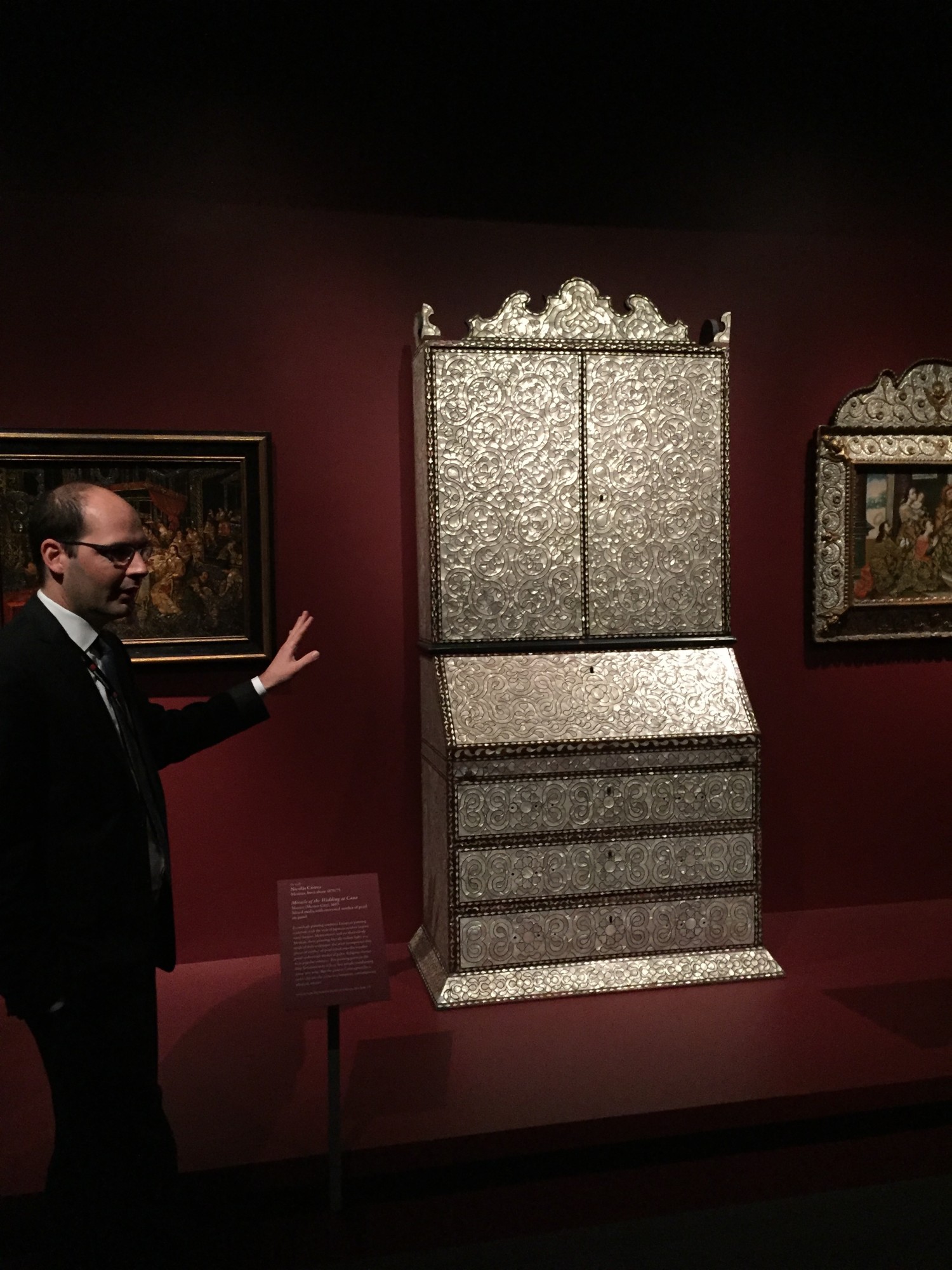 Dennis Carr standing in front of the desk from Lima, Peru, inlaid with mother-of-pearl on loan from the Newport Restoration Foundation