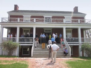 Trust members entering the Wilmer McLean House at Appomattox where Gen. R. E. Lee, spotless in his dress uniform, signed the surrender papers and offered his sword, and where Gen. Grant, mud covered after a long ride to get there, refused to take the sword. As they parted they doffed their hats to each other, a civilian gesture. The war was over.