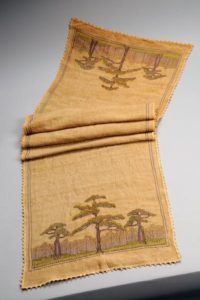 Figure 9. Example of needlework from Newcomb College. Table Runner with Southern Pine Design, unknown artist, 1905-1910. Silk thread on woven linen in running and outline stitches. Courtesy of the Newcomb Art Museum of Tulane University (1973.211.A).
