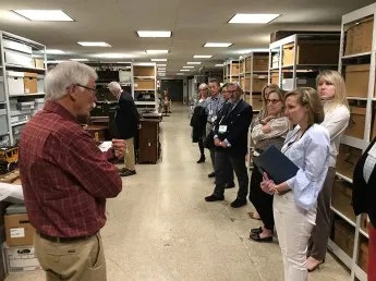 NYSM curator emeritus John Scherer showing participants through the furniture storage areas