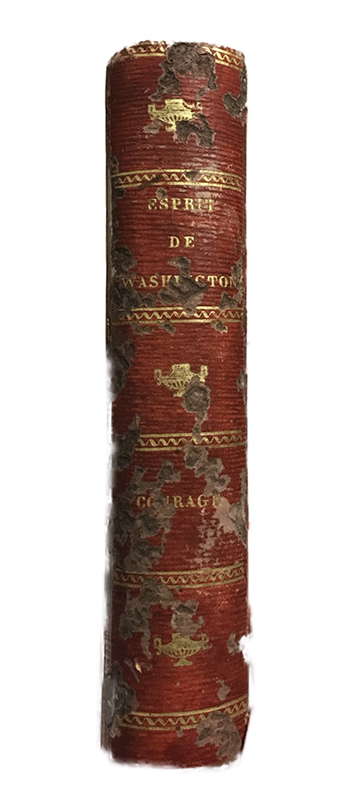 The “spine” of the book flask made of paper meant to imitate red Morocco leather binding. The spine also features surface decoration, including gilt lettering, raised bands, and lamp motifs, all popular bookbinding techniques used in the 19th century.