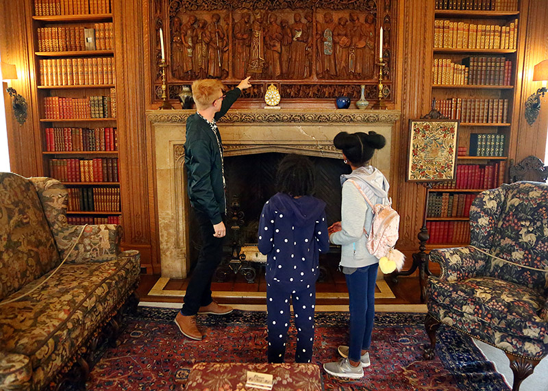 2016-2019 Center Collections Fellow Kevin Adkisson discusses Johannes Kirchmeyer’s overmantel (1918) in Cranbrook House with two young guests, October 6, 2018. Jin Kim, photographer. Courtesy Cranbrook Center Center for Collections and Research.