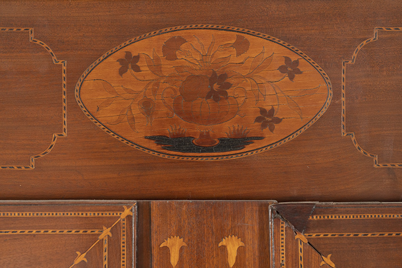 Detail of the Butterfly Man armoire seen above with an inlaid ovoid marquetry patera bearing a flowering Grecian urn.
