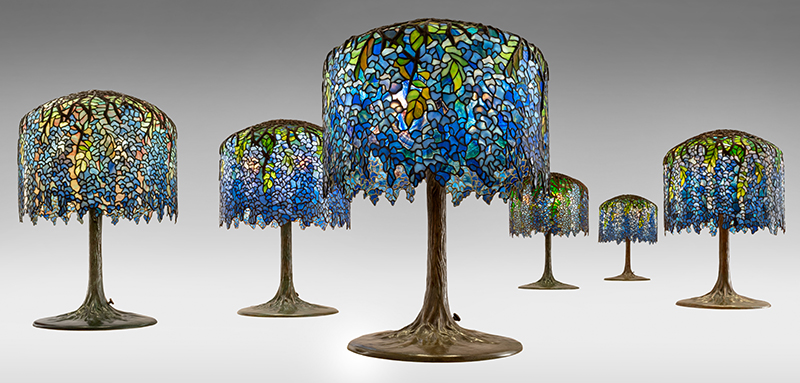 Figure 1. Grouping of six Wisteria lamps: two authentic examples by Tiffany Studios in front, c. 1905; four forgeries by unknown maker(s) in back, 1970s. Leaded glass, patinated bronze. All images courtesy The Neustadt Collection of Tiffany Glass, Queens, New York. All photos by David Schlegel.