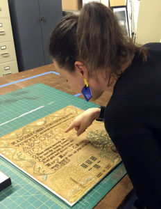 The author examines the Follet sampler at MESDA. Photo by Elyse Gerstenecker.