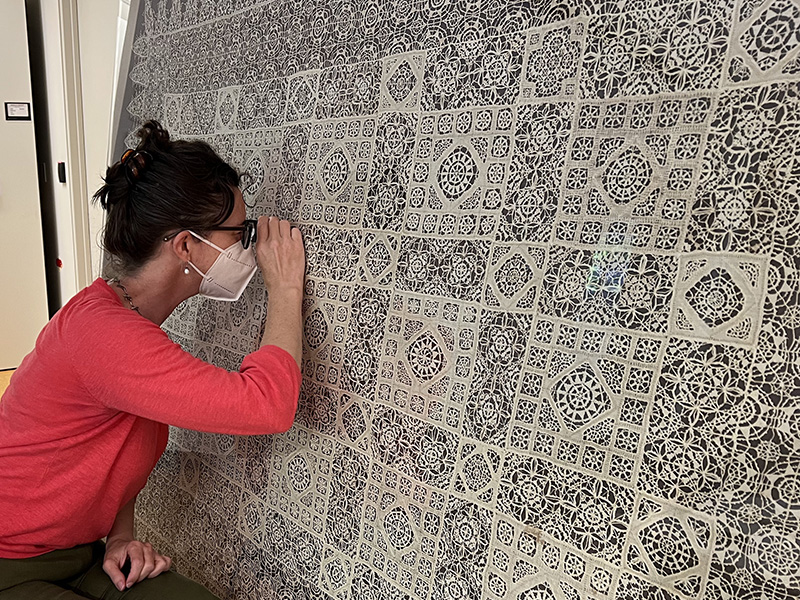 Figure 1. Cecilia Gunzburger examining a late 16th-century Italian lace cover (1930.656) at the Cleveland Museum of Art, June 24, 2022. Photo by Amanda Mikolic.