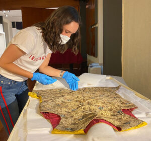 Figure 4. The author examines an 18th-century waistcoat (chupa) from the collection of the Museo Colonial in Bogotá, Colombia. Photo by Paula Guzmán López.