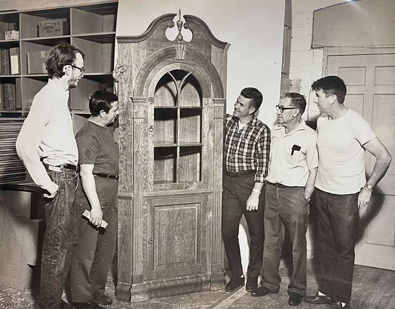 Figure 5. Berea staff Lloyd Kirby, William Jarvis, and Carl Richmond (center three) and Berea students (far left and far right) study a Wallace Nutting corner cupboard, c. 1965. Image courtesy of Berea College Special Collections and Archives.