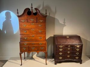 Figure 3. Gallery Installation, Whose Revolution, 2025. Pictured: Unknown Maker, High Chest, c. 1770, Concord, MA. Concord Museum Collection, Gift of Neil and Anna Rasmussen and anonymous donor, 1997.16. Desk, 1755–65, Boston, MA. Concord Museum Collection, Gift of Cummings E. Davis, F1407.