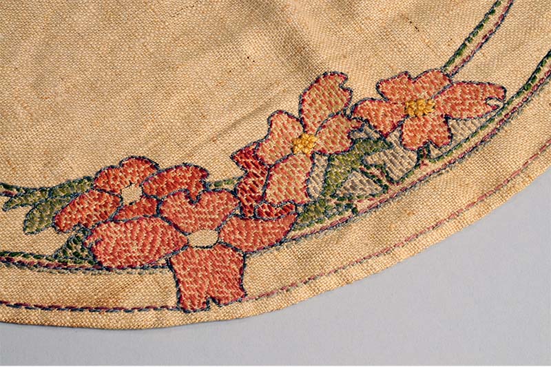 Placemat with dogwood design (detail), 1900–40, Louisiana. Silk embroidery on linen, Newcomb Art Museum of Tulane University, 2015.3. Photo courtesy of the Newcomb Art Museum.