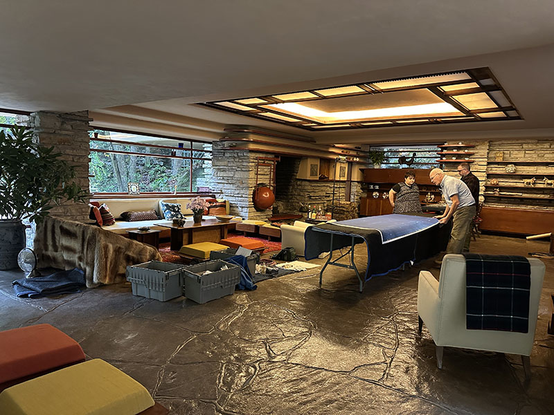 Fallingwater staff members pore over one of the oversized blueprints as they plan their work for the day.