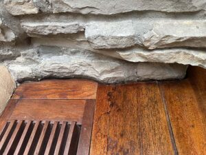 A detailed view of roughly dressed stone meeting the finished wood of a built-in desk.