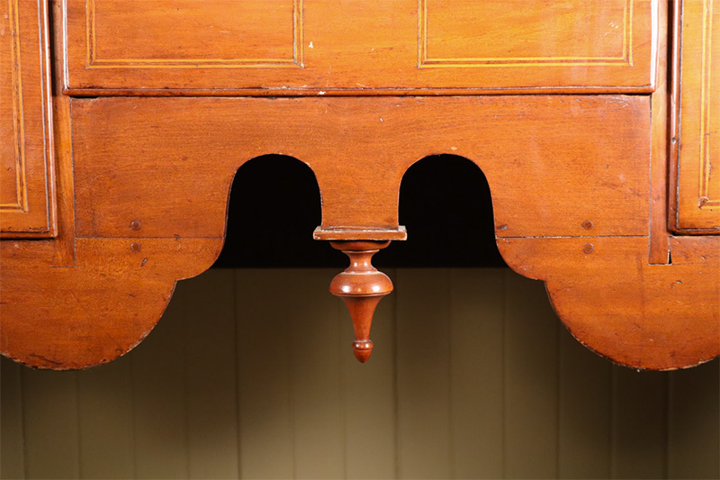 Detail of the unusual joinery on the apron of a High Chest of Drawers, ca. 1740. Flushing, Queens County, NY. Red gum; Atlantic white cedar, yellow poplar, pine, inlaid walnut and lightwood; replacement brass. Preservation Long Island, bequest of Huyler C. Held, 2013.3.