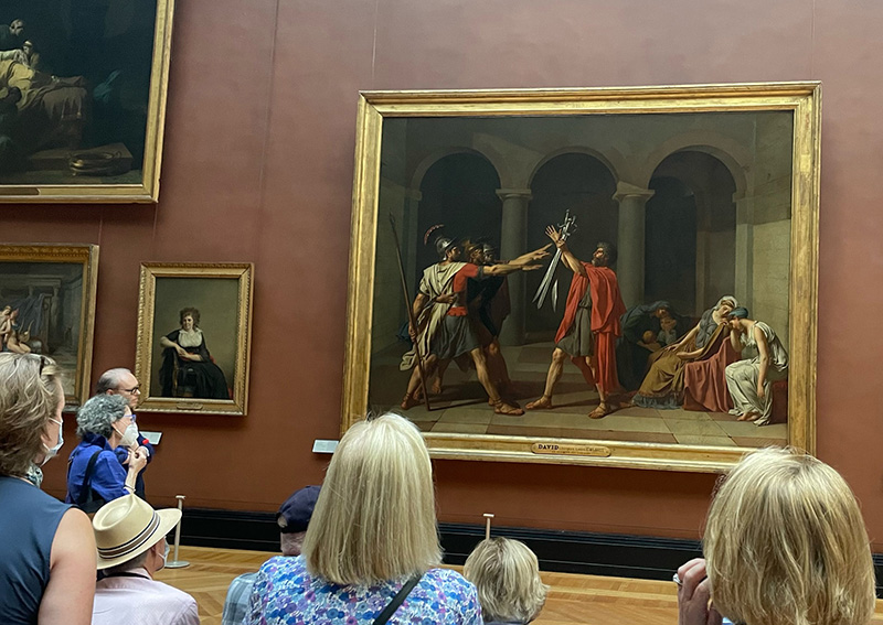 Figure 1. Members study Jacques-Louis David’s 𝘖𝘢𝘵𝘩 𝘰𝘧 𝘵𝘩𝘦 𝘏𝘰𝘳𝘢𝘵𝘪𝘪 (1784) at the Louvre during the fall 2023 Study Trip Abroad. Photo by author.